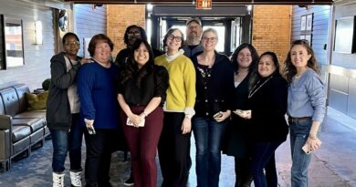 Interfaith Action's senior leadership team, program directors, and Project Home shelter managers stand in the lobby of the Bandana Blvd building on closing day. Photo Courtesy of Interfaith Action.