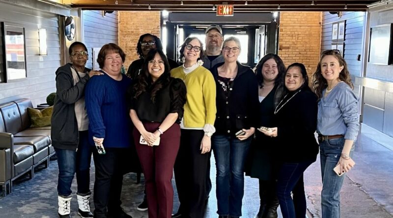Interfaith Action's senior leadership team, program directors, and Project Home shelter managers stand in the lobby of the Bandana Blvd building on closing day. Photo Courtesy of Interfaith Action.