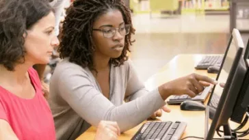 Two people accessing the internet on a St. Paul Public Library computer.