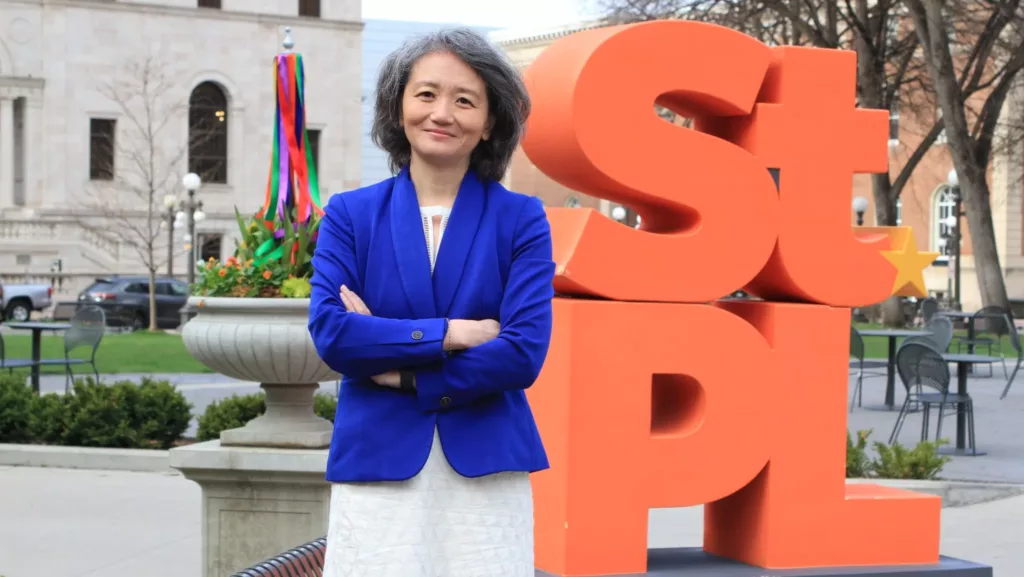 Yan Chen in front of a St. PL statue.