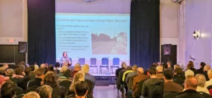 West 7th / Fort Road Federation Chair Meg Duhr presents at the Future of West 7th Town Hall on October 29, 2025. 